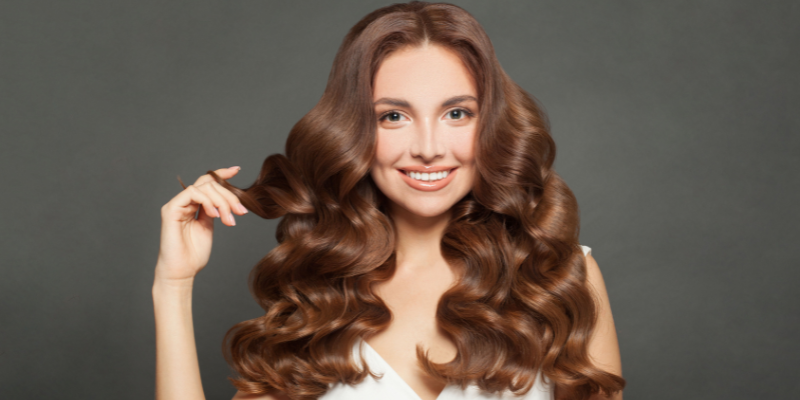 Woman with shiny, curly brown hair